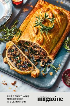 a meat dish on a platter with rosemary garnish and mushrooms in the middle