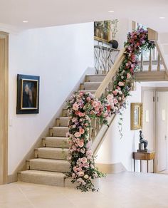 a staircase decorated with flowers and greenery for a wedding or special occasion in the house