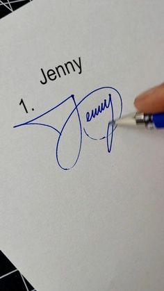 a person writing on a piece of paper with a pen