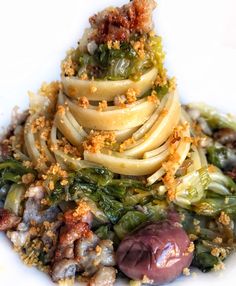 a white plate topped with pasta and vegetables