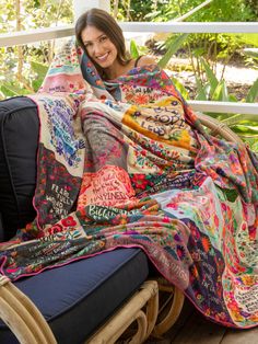 a woman sitting on a chair under a blanket