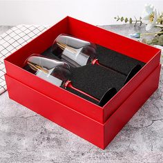 two wine glasses in a red box on a table