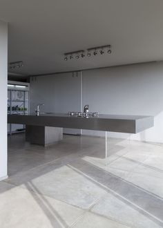 a modern kitchen with stainless steel appliances and counter tops in an empty room that is painted white