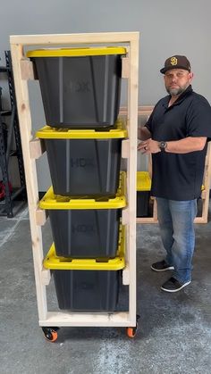 a man standing next to a stack of bins in a storage unit with wheels