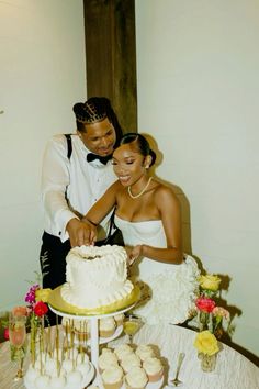 a bride and groom cutting their wedding cake