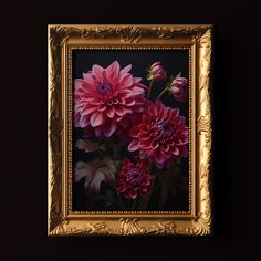 an ornate gold frame holds a painting of red dahlias in dark room with black background