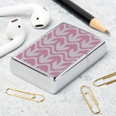 a pink and white lighter, earbuds, paper clips, and other items on a table