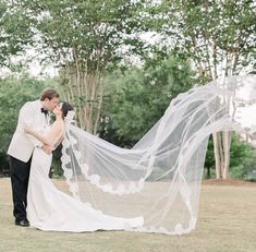 a bride and groom kissing under a veil