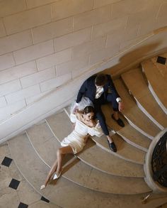 a bride and groom laying down on the stairs