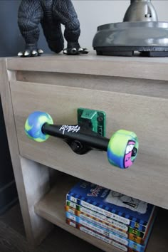 the skateboard is sitting on top of the wooden dresser drawer, which has been decorated with graffiti