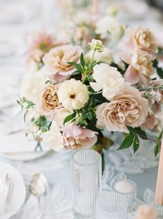 there are many flowers in the vases on the table together, and one is pink