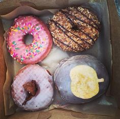 four donuts with different toppings in a box