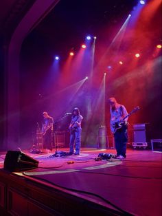 the band is performing on stage with bright lights