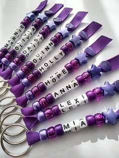 six purple and white hair clips with words written on them sitting next to each other