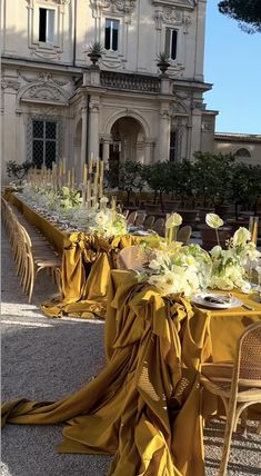 an outdoor dining area with tables and chairs covered in yellow cloths