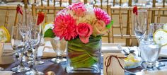 there is a vase filled with flowers on top of the table at this wedding reception