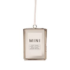 an ornament hanging from a string with the word mini in it's center