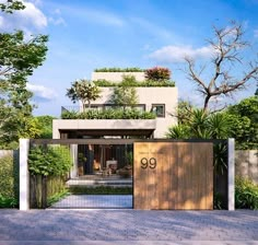 a modern house with an open gate and plants on the top floor, surrounded by greenery