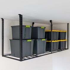 several bins are lined up on the wall with yellow and black shelves behind them