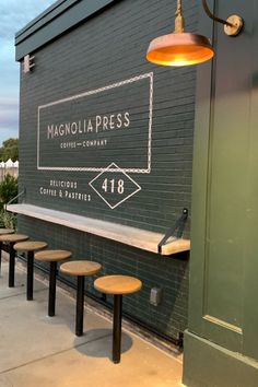 the outside of a restaurant with tables and stools in front of it that says magnolia press