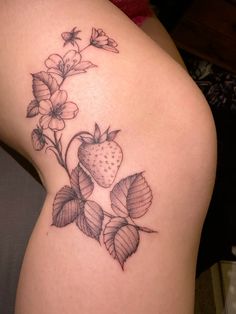 a woman's thigh with flowers and a strawberry tattoo on her left side ribcage