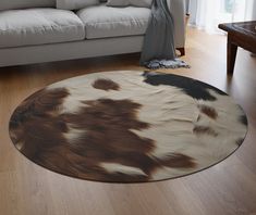 a living room with a couch and cow hide rug