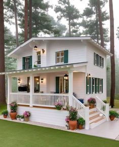 a white house with green shutters on the front porch and stairs leading up to it