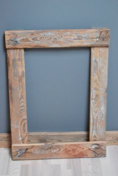 a wooden frame sitting on top of a hard wood floor next to a blue wall