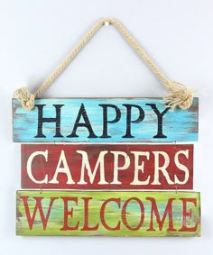 a wooden sign that says happy campers welcome