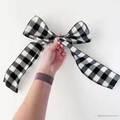 a woman is tying a black and white checkered bow