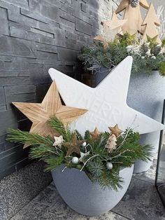 two star shaped planters with evergreen and pine cones in them