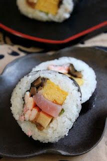 two black plates with sushi on them