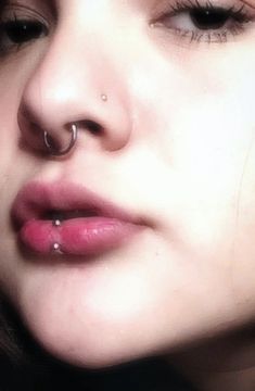 a woman with piercings on her nose looking at the camera