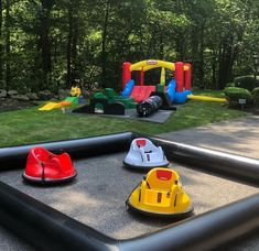 an inflatable bounce house with several toys on the ground and trees in the background