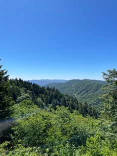 the view from top of a mountain looking down at trees and mountains