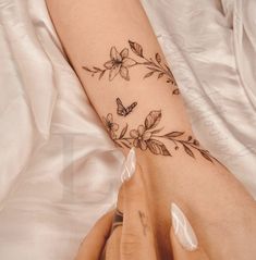 a woman's arm with flowers and butterflies on it