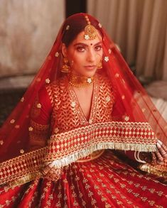 a woman in a red and gold bridal outfit