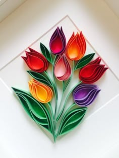 paper flowers are arranged in a square frame