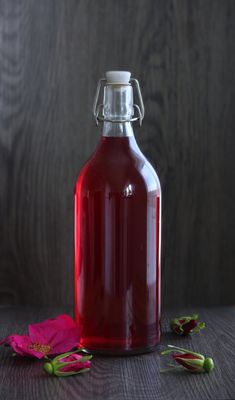 a bottle of liquid sitting on top of a wooden table