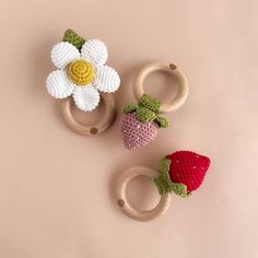 three crocheted rings with flowers and strawberries on them sitting next to each other