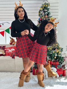 two women standing in front of a christmas tree