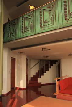 a living room with red couch and stairs