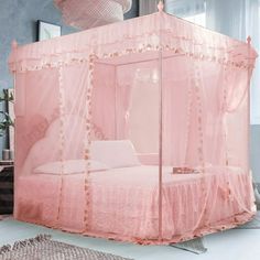 a pink canopy bed sitting on top of a white floor next to a rug and window