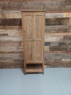 a tall wooden cabinet sitting in front of a wall with wood planks on it