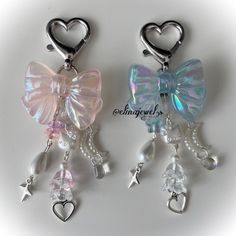 two charms with bows and hearts hanging from them