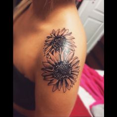 a woman's arm with a sunflower tattoo on the left side of her shoulder