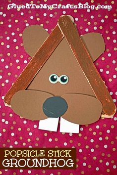 a brown bear made from popsicle sticks on top of a pink background with polka dots