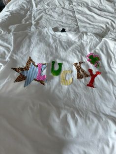 a white shirt with the word juicy spelled out in colorful letters on top of it