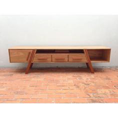 a wooden desk sitting on top of a brick floor