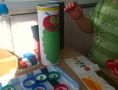 a child is playing with magnets on the table next to a cup and water bottle